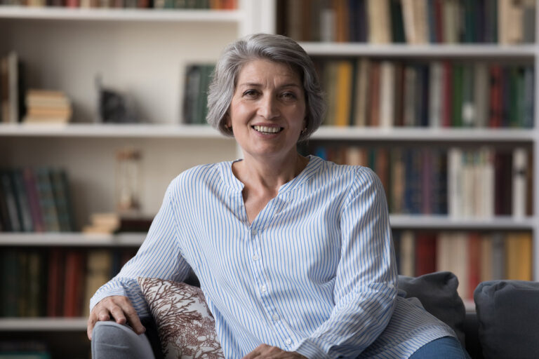 Happy attractive middle aged retired woman looking at camera.