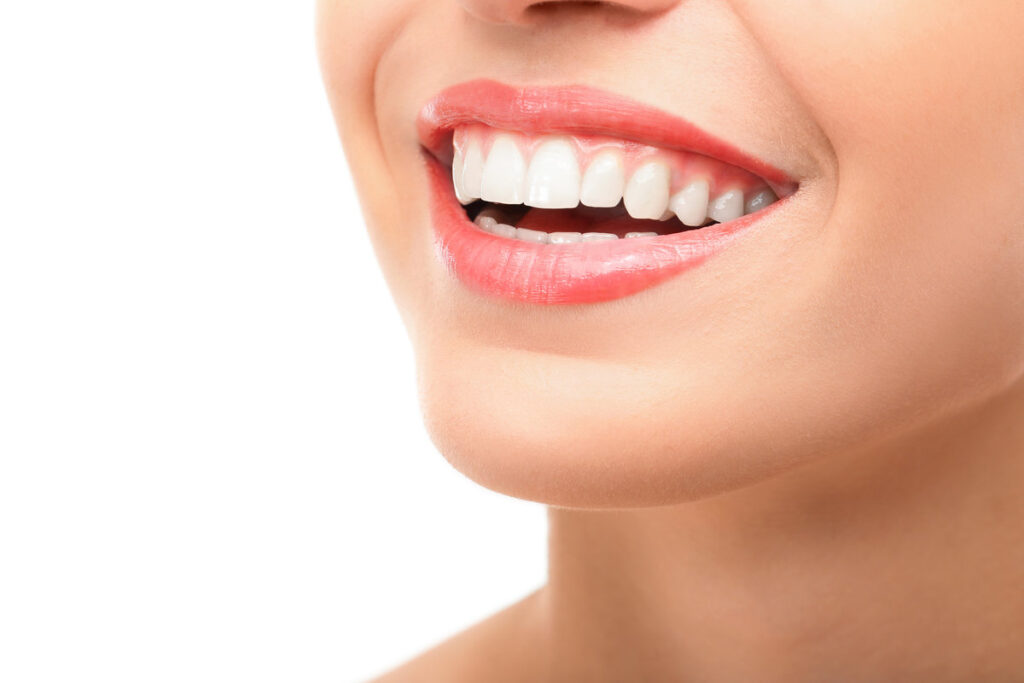 Beautiful young woman with healthy teeth on white background