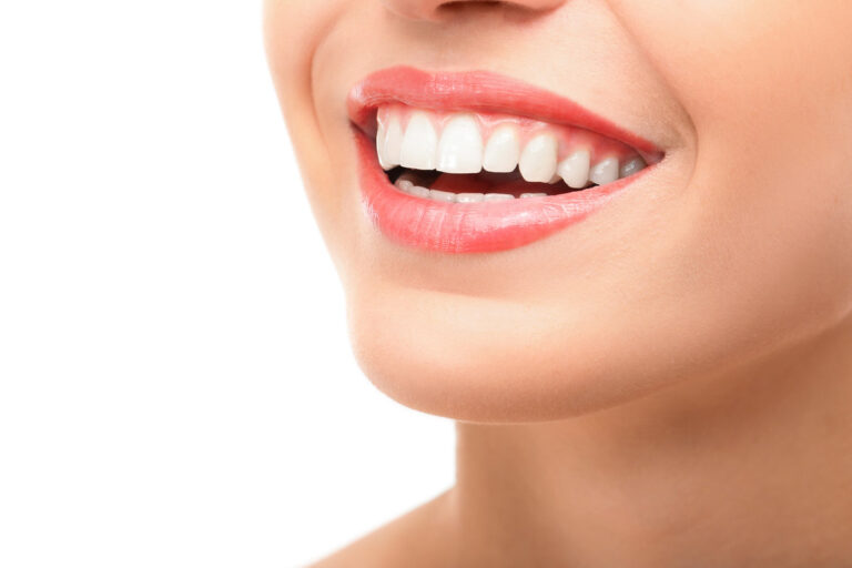 Beautiful young woman with healthy teeth on white background
