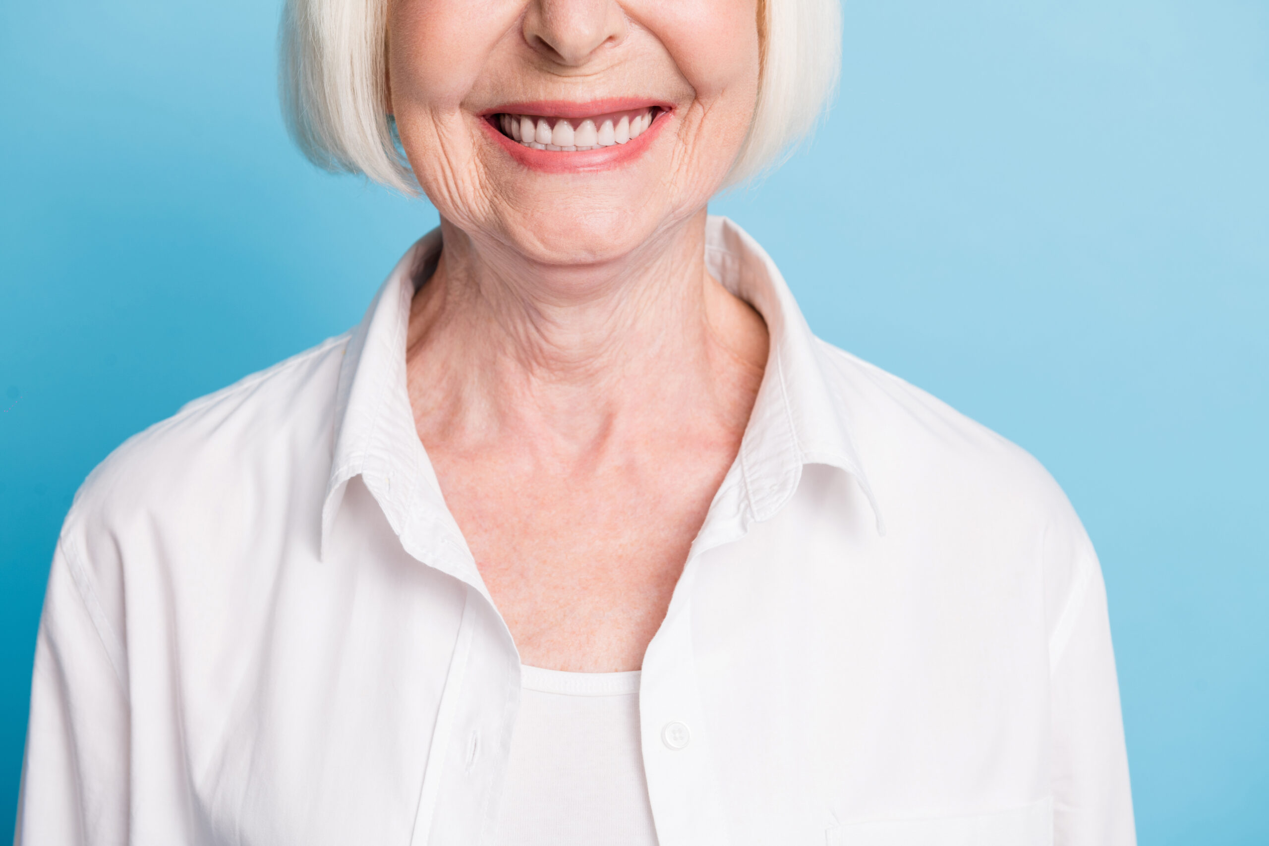 Smiling senior woman considering implant dentures and bone health at Countryside Dental